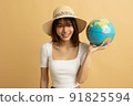 Young Asian girl dress in white shirt and jeans ready to travel on vacation on yellow isolated background 91825594