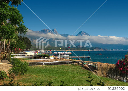 View of the path and the bridge in a green garden with green trees along the embankment in Kemer, Turkey. View of the path and the bridge in a green garden with green trees along the embankment in Kemer, Turkey. 91826902