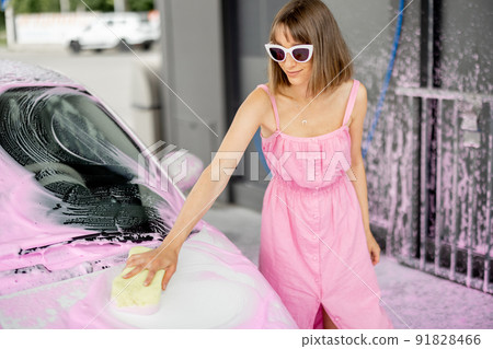 Woman washing her car at self-service car wash 91828466