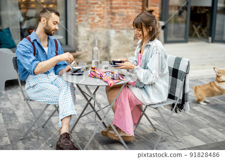 Stylish man and woman have delicious breakfast at cafe outdoors 91828486