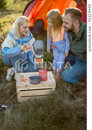 Couple with little girl cooking dried-food for hiking at campsite Couple with little girl cooking dried-food for hiking at campsite 91829449