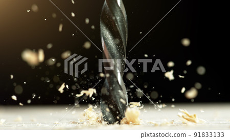 Super macro shot of steel drill with wood chippings flying off. 91833133