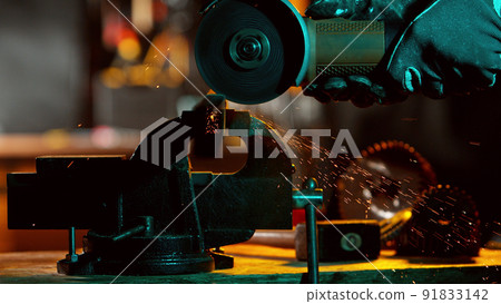 Detail of industry worker cutting steel pipe with flex saw 91833142