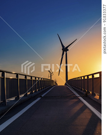 Shiosai Bridge on a bicycle path and a windmill for wind power generation at the mouth of the Kikukawa River in Kakegawa City, Shizuoka Prefecture at dusk Shiosai Bridge on a bicycle path and a windmill for wind power generation at the mouth of the Kikukawa River in Kakegawa City, Shizuoka Prefecture at dusk 91833377