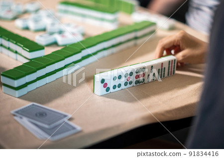 Women playing mahjong traditional Chinese board game at home 91834416