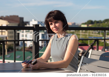 A woman emotionally invites friends to her table in a cafe 91836016
