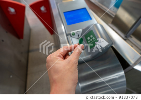 Taichung City, Taiwan - July 3, 2022 : Using one way ticket coin token walk through the fare pay zone exit gate of the Taichung MRT Metro system. Taichung City, Taiwan - July 3, 2022 : Using one way ticket coin token walk through the fare pay zone exit gate of the Taichung MRT Metro system. 91837078
