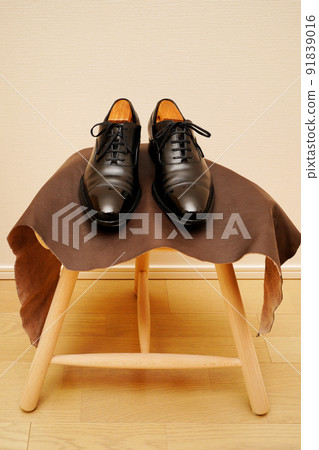 Black straight tip leather shoes on a stool Black straight tip leather shoes on a stool 91839016