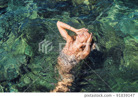 Beautiful emotional Model Girl in the sea. Beautiful Woman enjoying the Waves of the Ocean. vacation. Mediterranean Sea Beautiful emotional Model Girl in the sea. Beautiful Woman enjoying the Waves of the Ocean. vacation. Mediterranean Sea 91839147