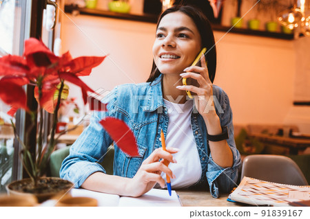 Happy young woman freelancer makes cell phone 91839167