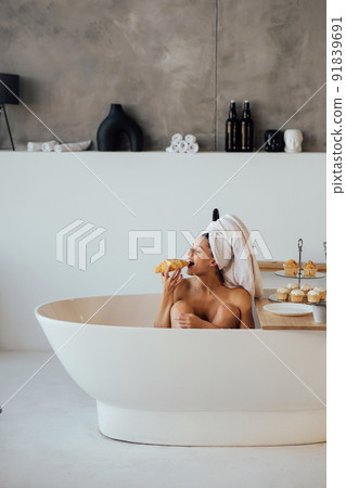 Luxury fashion woman in the morning take breakfast lying in bath Luxury fashion woman in the morning take breakfast lying in bath 91839691