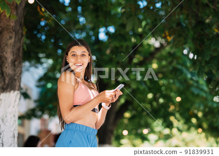 Photo of charming pretty young lady communicating modern gadget Photo of charming pretty young lady communicating modern gadget 91839931