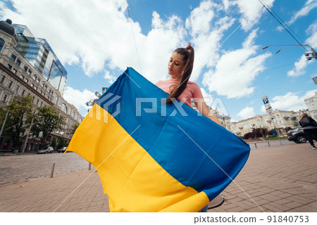 Young woman with national flag of Ukraine on the street Young woman with national flag of Ukraine on the street 91840753