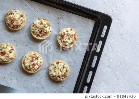 Mini Flammekueche, or tarte flambee, french specialty, on the oven-tray Mini Flammekueche, or tarte flambee, french specialty, on the oven-tray 91842430