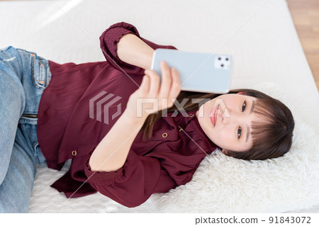 A young woman operating a smartphone A young woman operating a smartphone 91843072