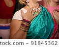 Female neck and hands with many boho bracelets, leather necklace and earrings with feathers, turquoise and brown. 91845362