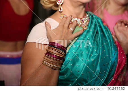 Female neck and hands with many boho bracelets, leather necklace and earrings with feathers, turquoise and brown. Female neck and hands with many boho bracelets, leather necklace and earrings with feathers, turquoise and brown. 91845362