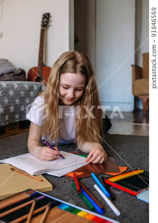 The girl after school plays at home, draws with pencils and felt-tip pens 91846569
