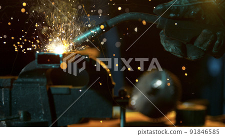Freeze Motion of Working Welder in Workshop. Detail shot, low depth of focus. Freeze Motion of Working Welder in Workshop. Detail shot, low depth of focus. 91846585