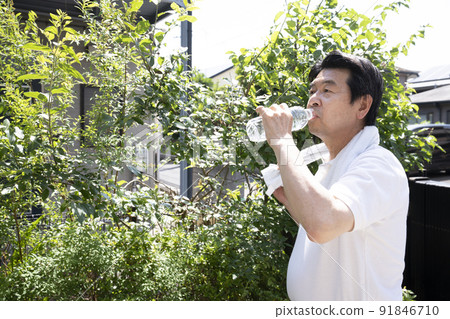 一個男人從塑料瓶裡喝水補充水分 一個男人從塑料瓶裡喝水補充水分 91846710