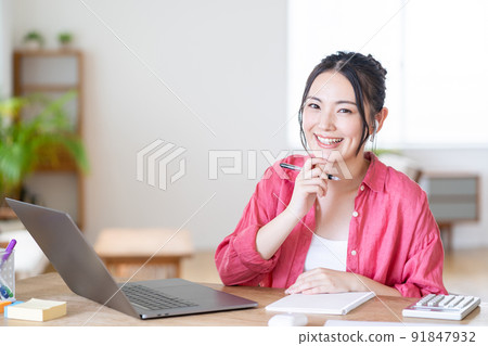 A young woman doing telework in the living room. 91847932