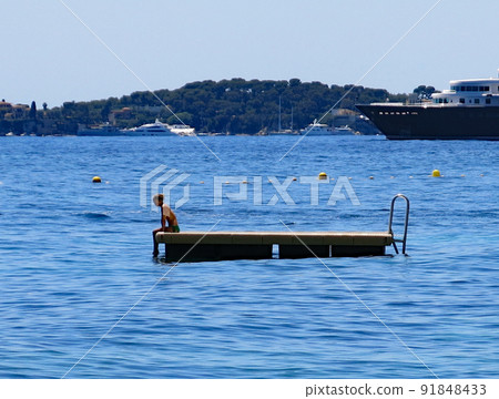 法國蔚藍海岸埃茲,漂浮在海面上的漂浮物上的女人 法國蔚藍海岸埃茲,漂浮在海面上的漂浮物上的女人 91848433