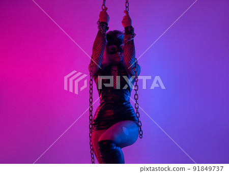 Sexy girl in latex dress bdsm mistress and cat mask in neon light with chains for sex game Sexy girl in latex dress bdsm mistress and cat mask in neon light with chains for sex game 91849737