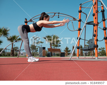 a sporty girl does fitness on a sports field in the summer outdoors a sporty girl does fitness on a sports field in the summer outdoors 91849937
