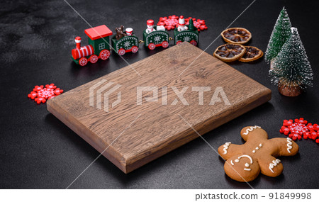 Christmas homemade gingerbread cookies, spices and cutting board on dark background Christmas homemade gingerbread cookies, spices and cutting board on dark background 91849998