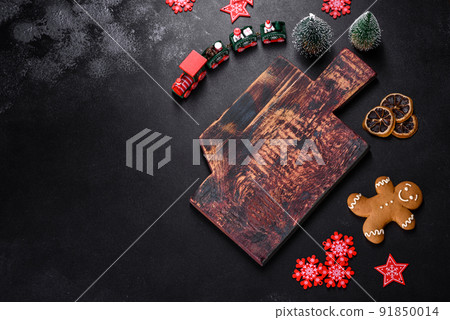 Christmas homemade gingerbread cookies, spices and cutting board on dark background Christmas homemade gingerbread cookies, spices and cutting board on dark background 91850014