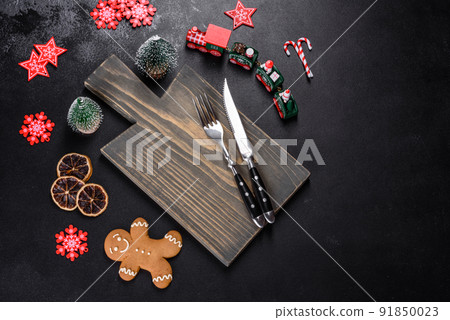 Christmas homemade gingerbread cookies, spices and cutting board on dark background 91850023
