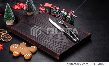 Christmas homemade gingerbread cookies, spices and cutting board on dark background Christmas homemade gingerbread cookies, spices and cutting board on dark background 91850025