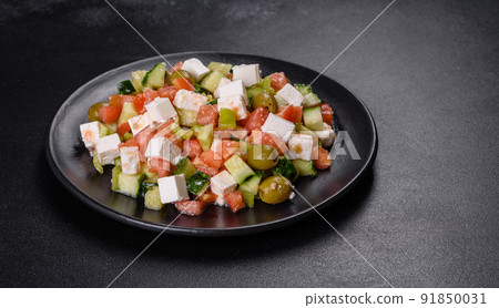 Greek salad with juicy tomatoes, feta cheese, lettuce, green olives, cucumber, red onion and fresh parsley 91850031