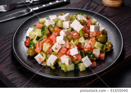 Greek salad with juicy tomatoes, feta cheese, lettuce, green olives, cucumber, red onion and fresh parsley Greek salad with juicy tomatoes, feta cheese, lettuce, green olives, cucumber, red onion and fresh parsley 91850040