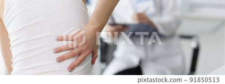 Female patient complain on back pain and touch side of body 91850513