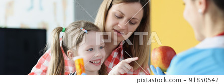 Happy little girl choose apple instead of bottle of medications 91850542