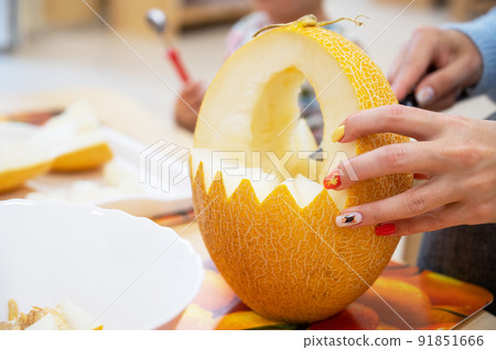 Female hands cutting pumpkin to halloween 91851666