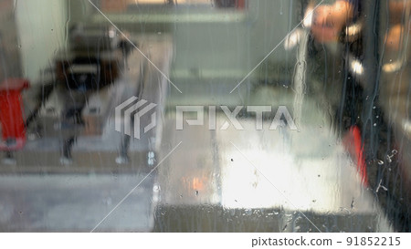 Worker is washing plant mill machine using a metal water sprayer. Worker is washing plant mill machine using a metal water sprayer. 91852215