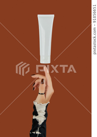 Womans hand with cosmetic cream or cleanser on brown background Womans hand with cosmetic cream or cleanser on brown background 91856651