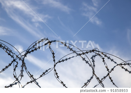 old barbed wire on the fence to protect the territory 91858933