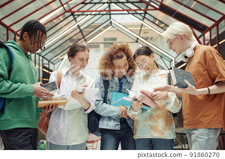 Group of multicultural teenage guys and girls looking through lecture notes 91860270