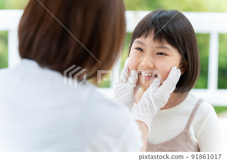 A girl undergoing a dental examination 91861017