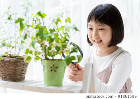 一個女孩用放大鏡觀察觀葉植物 91861589