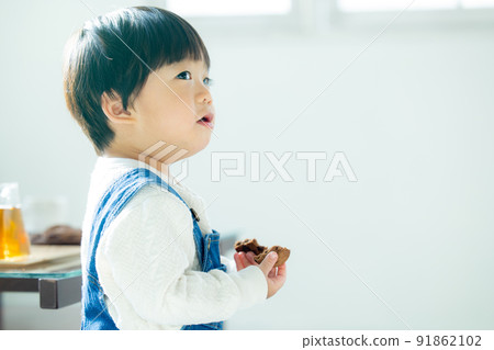 1 year old boy eating cookies 91862102