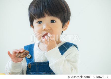 1 year old boy eating cookies 91862107