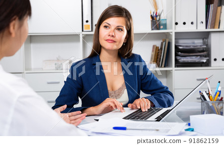 Smiling business woman communicates with a colleague in the office Smiling business woman communicates with a colleague in the office 91862159