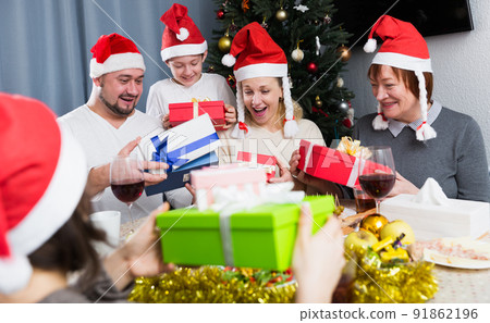 Cheerful family exchanging Christmas gifts Cheerful family exchanging Christmas gifts 91862196