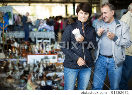 Man and his wife are visiting market of old things Man and his wife are visiting market of old things 91862681