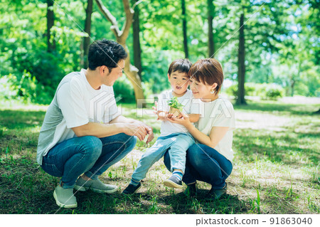 A family with a small potted plant in the woods 91863040