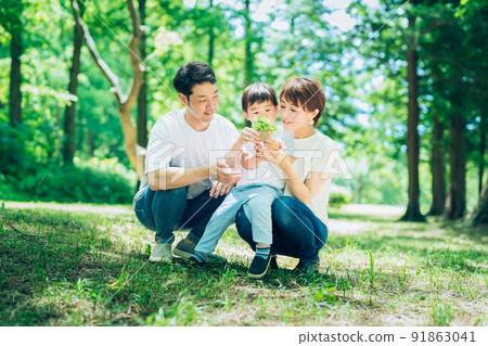 A family with a small potted plant in the woods A family with a small potted plant in the woods 91863041